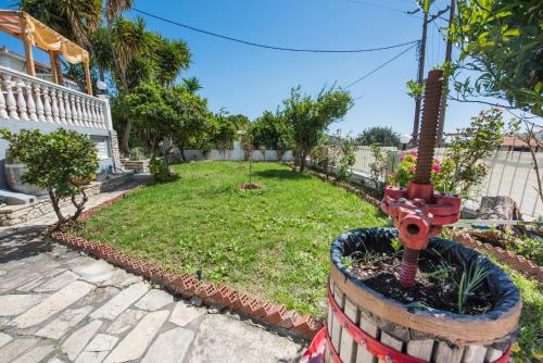 a garden with a red machine in the middle at Anthis Studios in Pythagoreio