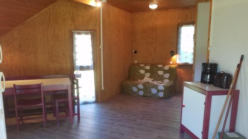 a living room with a couch and a table at Camping Domaine du Lac Chambon in Murol