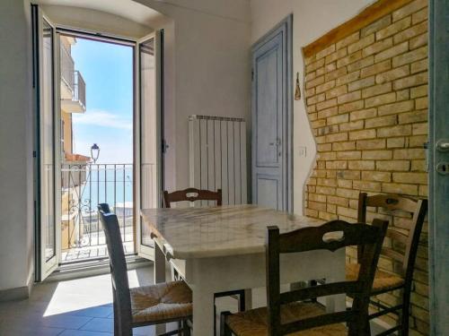 a table and chairs in a room with a balcony at LA FINESTRA SUL MARE in Ortona
