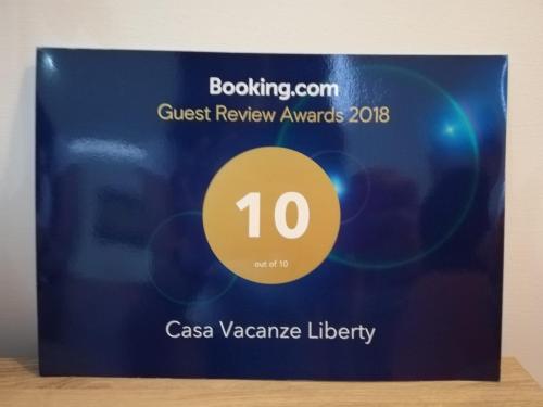 a sign for a guest review awards with a yellow circle at Casa Vacanze LIBERTY in Licata