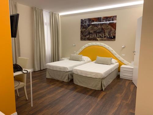 a hotel room with two beds and a tv at 7 Bell's House in Civitavecchia