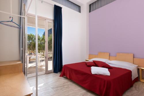 a bedroom with a bed with a red blanket at Vitorno Residence in San Vito lo Capo