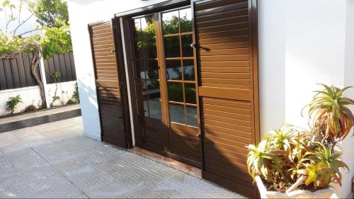 a wooden door to a house with some plants at Country House Alfarim in Alfarim