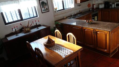 a kitchen with a wooden table and a kitchen with a sink at Country House Alfarim in Alfarim