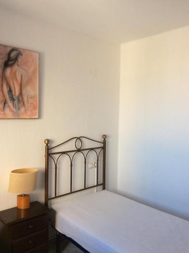 Un dormitorio con una cama y un cuadro en la pared. en Tus vacaciones junto al mar, en Torrevieja
