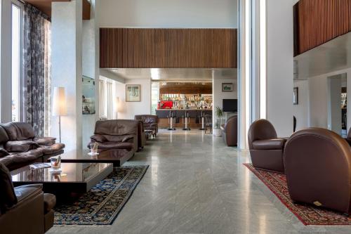 a lobby with couches and chairs and a bar at Hotel Bellevue in Rimini