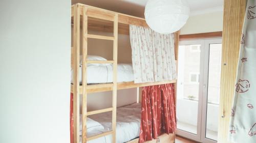 um beliche num quarto com uma janela em Oportocean Hostel em Matosinhos