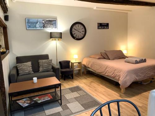 1 dormitorio con cama, sofá y reloj en Lovely studio Le Marais en París