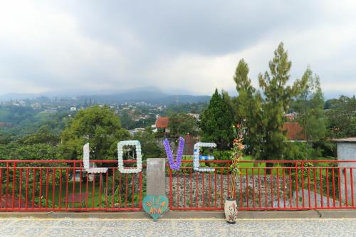 a red gate with a view of a city at Villa Ana in Pasuruan