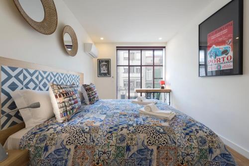 - une chambre avec un lit doté d'un couvre-lit bleu et blanc dans l'établissement Contemporary Flat near São Bento by LovelyStay, à Porto