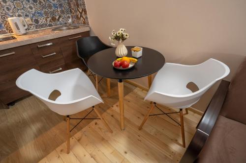 a kitchen with a table and two chairs and a bowl of fruit at Wine Inn Borjomi Aparthotel in Borjomi