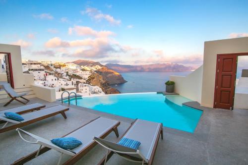 a villa with a pool and a view of the ocean at Aloia Villas in Oia
