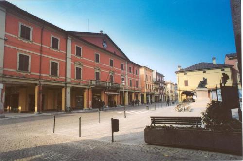 una strada con edifici e panchina in una città di Locanda del Re a Crevalcore