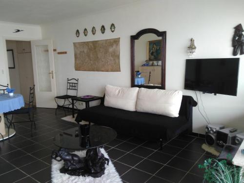 uma sala de estar com um sofá e uma televisão de ecrã plano em Residentie Aldis met zeezicht em Oostende