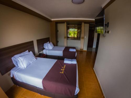 a hotel room with two beds and a television at Gran Hotel Panorama in Quillabamba