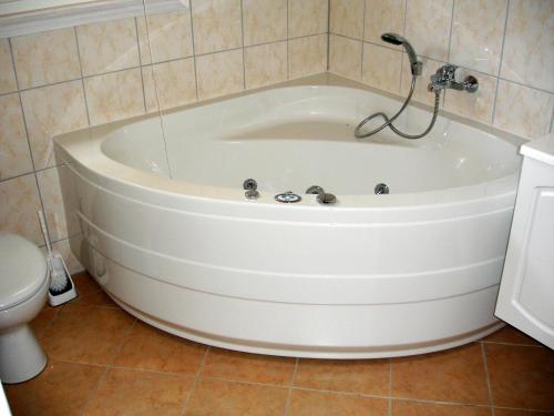 a white bath tub in a bathroom with a toilet at Strandhaus Deichkrone in Baabe
