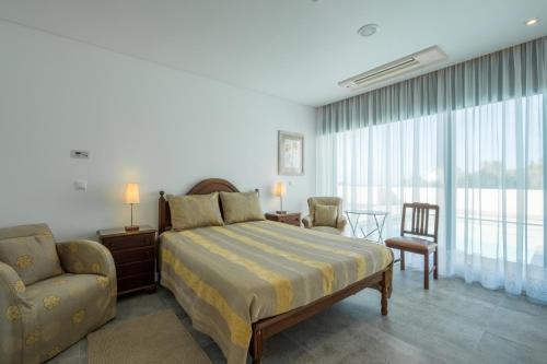 a bedroom with a bed and a couch and a chair at Bela Vista da Luz 17 by Destination Algarve in Luz