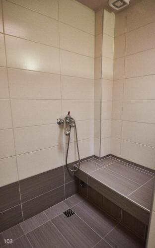 a shower in a bathroom with a tile floor at Atlantic Hotel in Athens