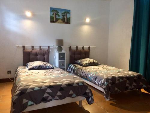 2 nebeneinander sitzende Betten in einem Schlafzimmer in der Unterkunft B&B La Viderente in Saussignac