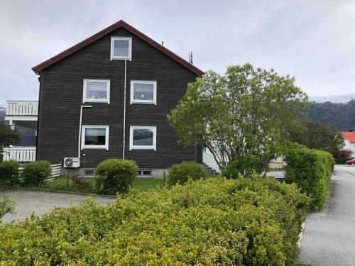 a brown house with white windows on a street at Åndalsnes Apartments - Luxury Stay in Åndalsnes