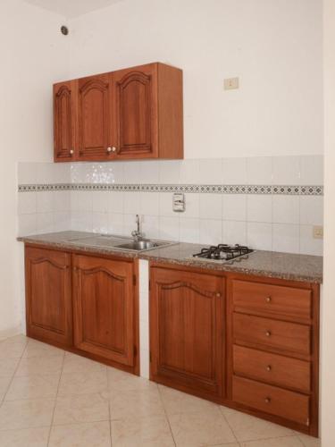 a kitchen with wooden cabinets and a sink at Baia Unci in Canneto