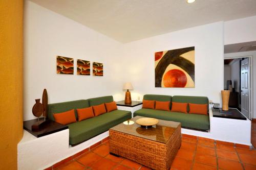 a living room with a couch and a table at Las Palmas Condominio in Playa del Carmen