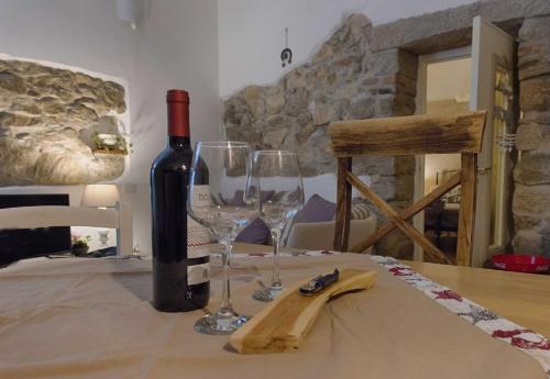 a bottle of wine and two glasses on a table at La casetta al centro di Olbia in Olbia