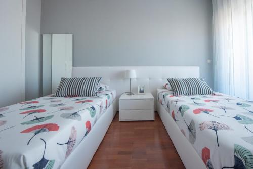 two beds sitting next to each other in a bedroom at Apartamento Mouzinho de Albuquerque in Matosinhos