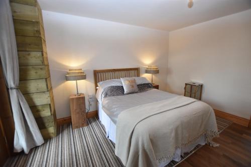 a bedroom with a bed and two lamps in it at Oak tree stables cottage in Birmingham