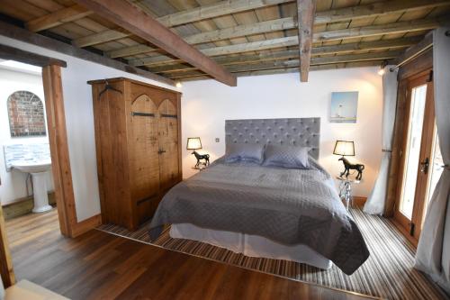 Schlafzimmer mit einem Bett und Holzboden in der Unterkunft Oak tree stables cottage in Birmingham