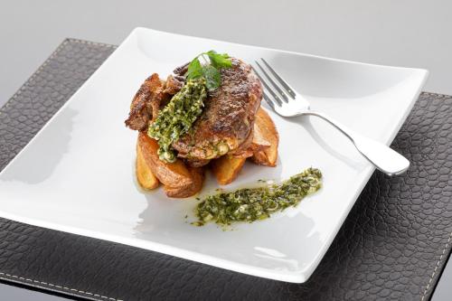a white plate with a piece of food and a fork at Nobile Hotel Estación Central in Santiago