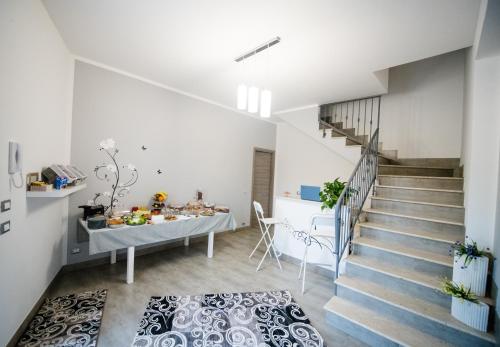 een woonkamer met trap en een eettafel bij Dove sorge il sole in Custonaci