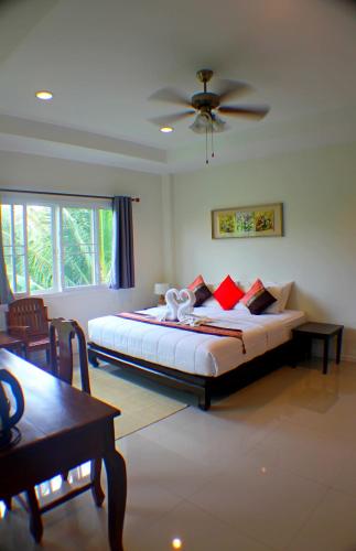 a bedroom with a bed and a ceiling fan at Baan Glangsuan Bang Kobua in Bang Chak