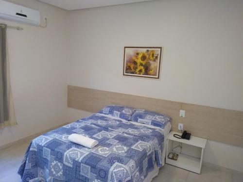 Santa Maria da VitóriaにあるHotel Portal do Correnteのベッドルーム1室(ベッド1台付)が備わります。壁に絵が飾られています。