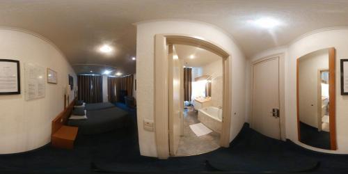 pasillo de una habitación de hotel con baño y espejo en Hotel Professor, en Lovaina