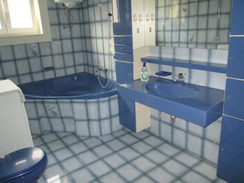 łazienka z 2 umywalkami i niebieską wanną w obiekcie Velin Apartment w Splicie