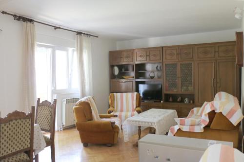 a living room with chairs and a couch and a tv at Velin Apartment in Split