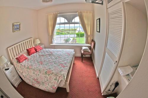 ein kleines Schlafzimmer mit einem Bett und einem Fenster in der Unterkunft Sea Breeze Bed and Breakfast in Cahersiveen
