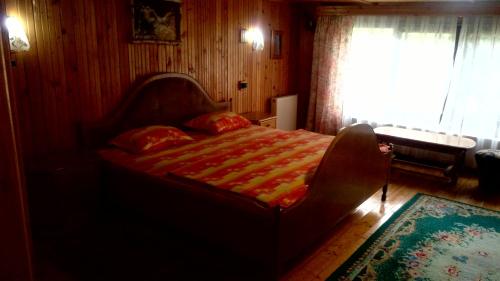 a bedroom with a bed in a room with a window at pensiunea Gabriela in Durau
