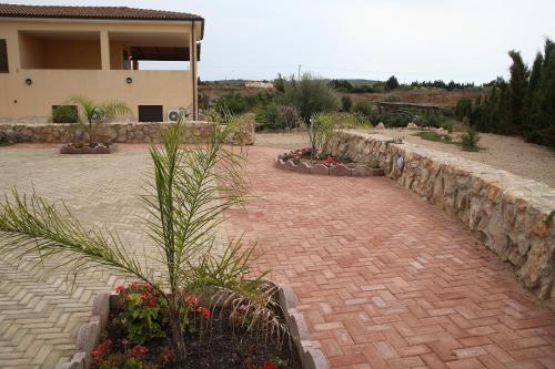 a brick walkway in front of a house with plants at Villa Sorrentina in Alghero