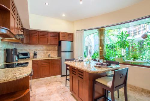a kitchen with wooden cabinets and a large window at Maya Villa Condo Hotel and Beachclub in Playa del Carmen