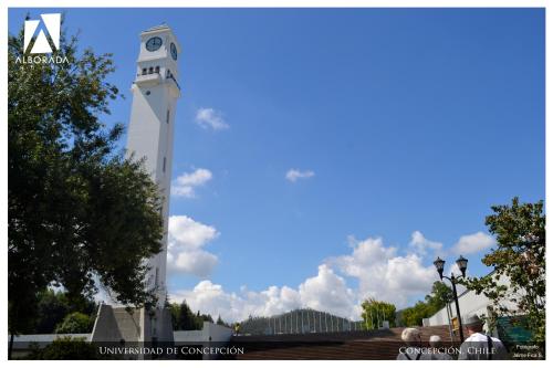 a tall white clock tower with a clock on it at Hotel Alborada in Concepción