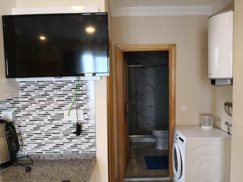a bathroom with a toilet and a television on the wall at Gumul pansiyon in Uzungöl
