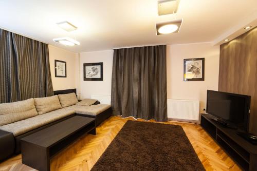 a living room with a couch and a flat screen tv at Apartments Neivado in Zlatibor