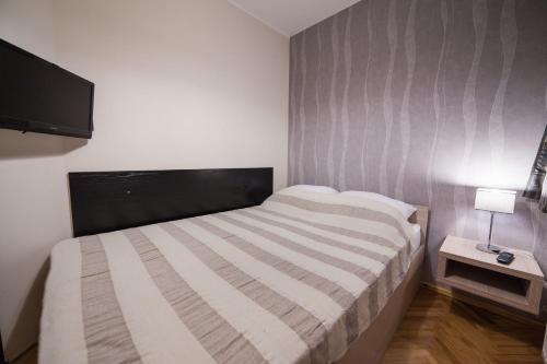 a small bedroom with a bed and a television at Apartments Neivado in Zlatibor