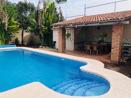a swimming pool in front of a house at Casa Balam in Rincon de Guayabitos