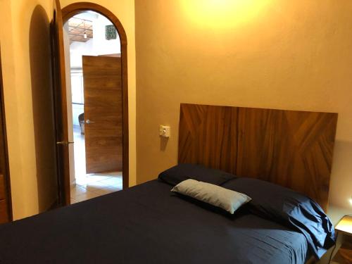 - une chambre avec un lit doté d'une tête de lit en bois dans l'établissement Casa Balam, à Rincon de Guayabitos