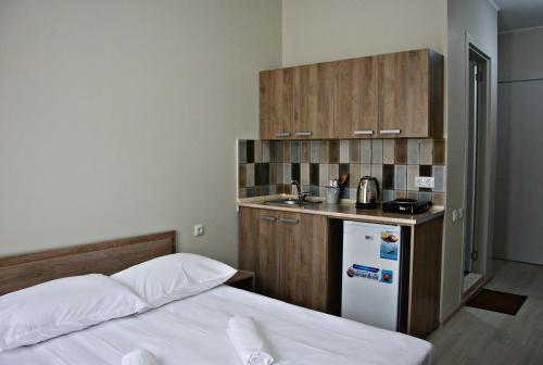 a bedroom with a bed and a small kitchen at Apartments On Vaja Pshavela in Batumi