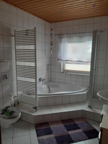 a bathroom with a tub and a sink and a toilet at Ferienwohnung Heck in Waldeck