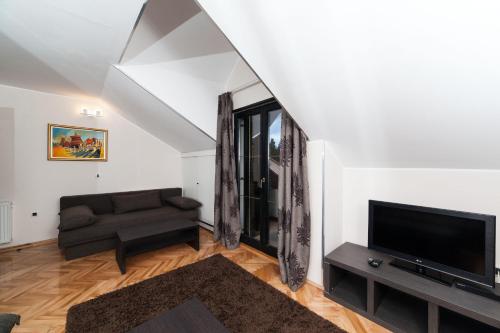 a living room with a couch and a flat screen tv at Apartments Neivado in Zlatibor